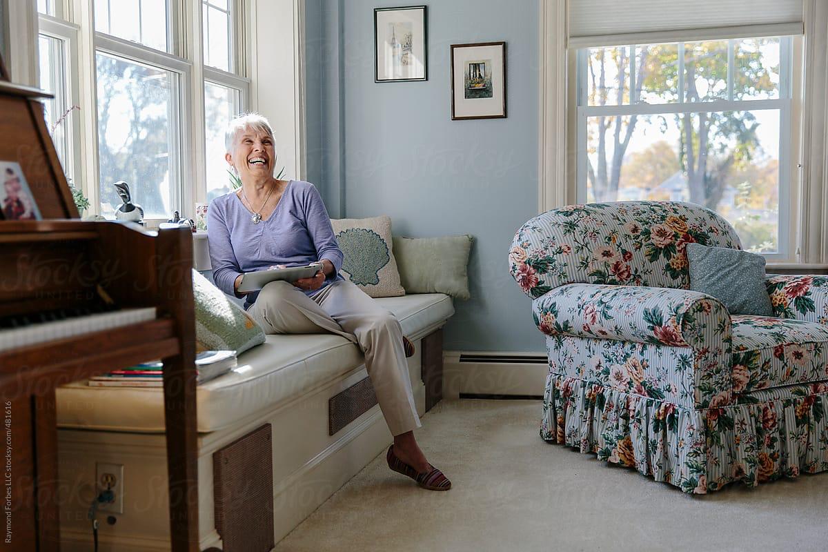 Older woman laughing in living room
